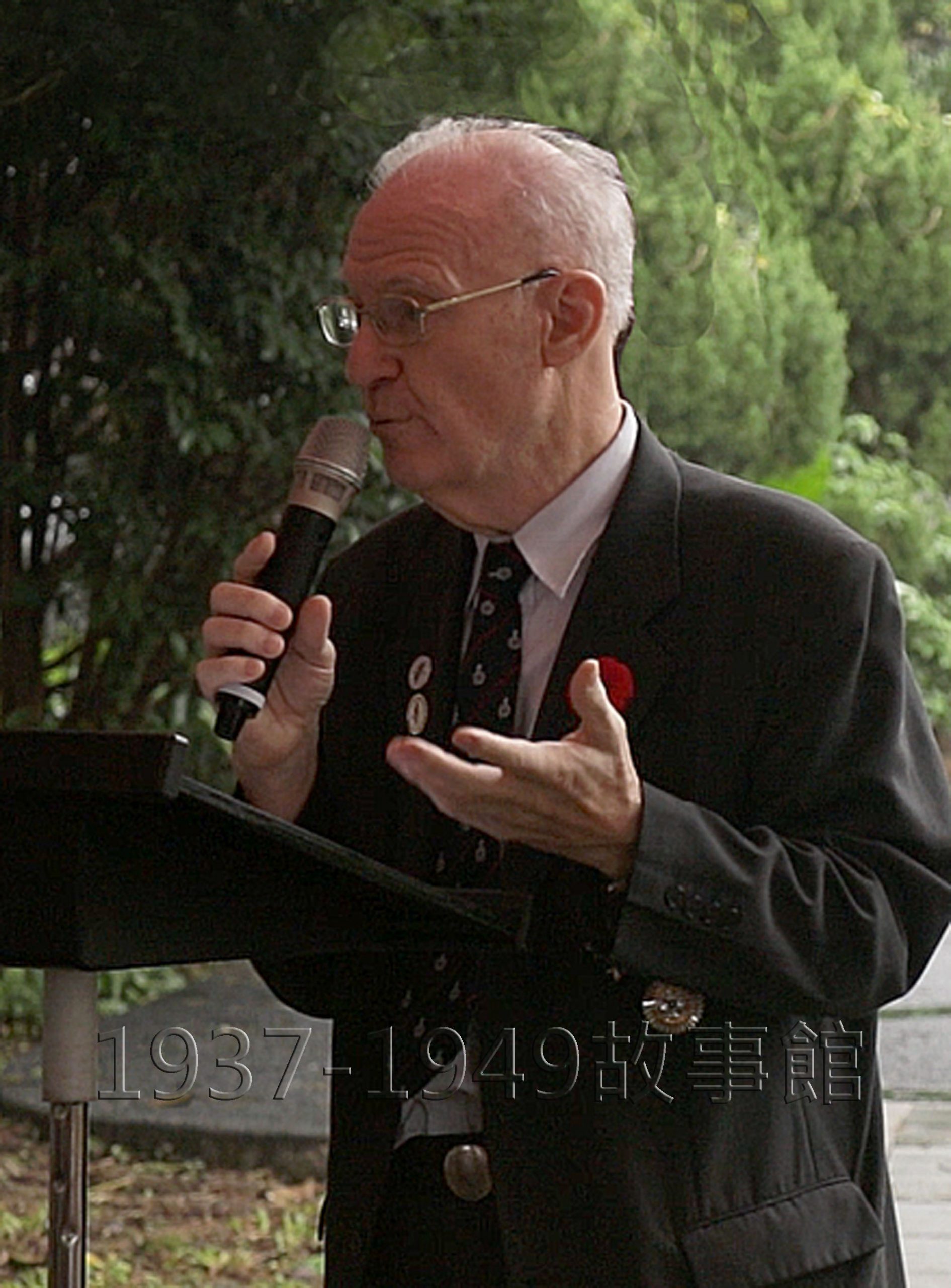 圖六 主辦此項活動的「台灣戰俘營紀念協會」理事長何麥克致詞。（攝影 賈誌承、背景調修）