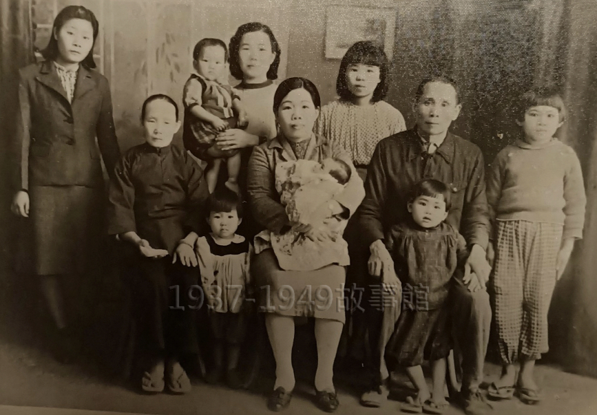 圖一 右二坐著的是作者劉瓊琳的外祖父，他雙腿攬著的是當時已約莫4歲的作者母親王富美（也是本文所寫的「阿嬤」）；外祖父旁坐著的是外祖母，抱著剛滿月的舅舅；最右方站著的則是作者母親的大姊，約9歲餘。