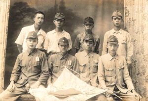 圖二 台籍日本兵於出征前在攝影社內合影，前排右者手持日本軍旗。（來源：維基百科）